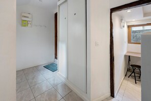 A hallway with a door, a light switch, and a window with a view. - Apartment 'Logement Cosy Centre Joigny' with Wi-Fi (Joigny)