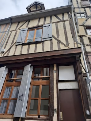 A half-timbered building with a wooden door, a window with shutters, and a visible number '9' on the wall. - Apartment 'Cosy Hypercentre Joigny' with Wi-Fi (Joigny)