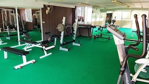 A gym with various exercise equipment, including treadmills, weight machines, and benches. - Jomtien Beach Residence (Pattaya)