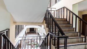 A multi-level interior with a central staircase, a circular balcony, and a view of the lower level. - Jomtien Beach Residence (Pattaya)