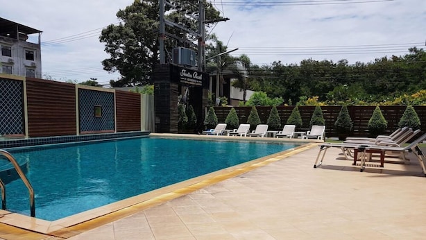 A swimming pool with lounge chairs and a wooden deck. - Jomtien Beach Residence (Pattaya)
