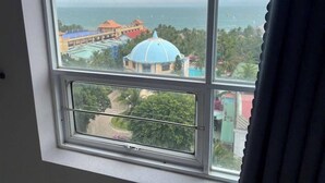 A view from a window overlooking a coastal area with buildings and a dome structure. - Nam Hai Hotel (Phan Thiet)