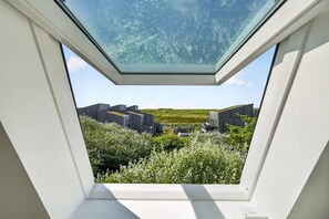 A skylight window with a view of buildings and greenery. - Hüs lepen Will - Stylish vacation home for 4 people with sauna, garden and (Hörnum (Sylt))