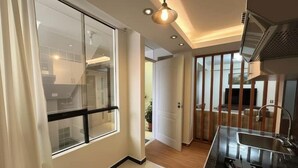 A modern kitchen with a black countertop, a sink, and a window with a view of the outside. - Brand new apartment with private jacuzzi. (Cusco)
