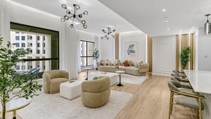 Ein modernes Wohnzimmer mit einer Sofagarnitur, einem Couchtisch und einem Essbereich mit Stühlen.
