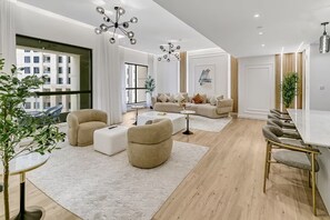 A modern living room with a sofa set, a coffee table, and a dining area with chairs. - Sadaf 1507 (Dubai)