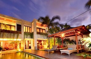 A hotel with a pool, outdoor seating, and a covered area. - THE Artisane Villa (Seminyak)