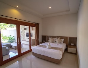 A modern bedroom with a large bed, a sliding glass door to a balcony, and a clean, minimalist design. - Juada Garden (Seminyak)