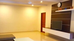 A modern living room with a flat-screen TV, a sofa, and a coffee table. - Juada Garden (Seminyak)
