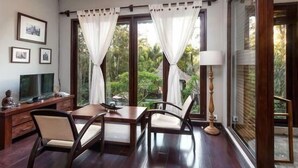 A room with a wooden table and chairs, a TV, and a lamp.