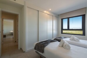 Ein modernes Hotelzimmer mit zwei Betten, einem großen Fenster und Blick auf die Landschaft.