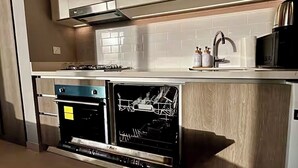 Una cucina moderna con elettrodomestici integrati, tra cui lavastoviglie e forno, e un microonde sul piano di lavoro.