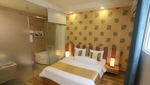 Ein Hotelzimmer mit einem großen Bett, einer Glasdusche und einer Wand mit Muster.