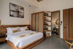A bedroom with a wooden bed, a built-in wardrobe, a bedside table, and a wall-mounted shelf. - Serenity Villa Jimbaran (Bali)