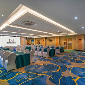 A conference room with tables and chairs, a projector screen, and a carpet with a blue and yellow pattern. - Guangzhou Ming YUE Hotel (Guangzhou)