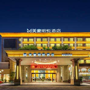 Ein Hotel mit markantem Eingang, beleuchteter Beschilderung und modernem Architekturstil.