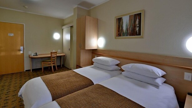 A hotel room with two beds, a desk, and a chair. - Road Lodge Gqeberha Airport (Gqeberha)
