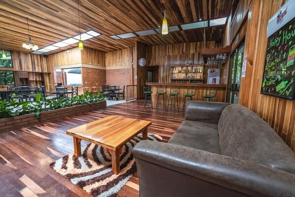 A modern interior with wooden paneling, a bar area, and seating arrangements. - Monteverde Luxury Hotel (Monteverde)
