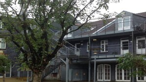 A multi-story building with a staircase leading to an upper balcony. - Herning City Apartments (Herning)