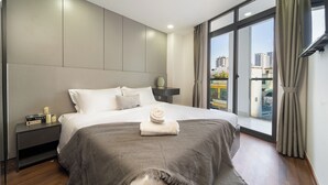 Une chambre d’hôtel moderne avec un grand lit, une table de chevet, une fenêtre avec des rideaux et une vue sur la ville.
