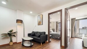 Un salon moderne avec un canapé, une petite table, un lampadaire et une plante en pot.