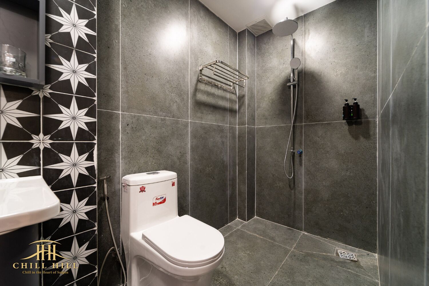 Une salle de bain équipée de toilettes, d’une douche et d’un porte-serviettes.