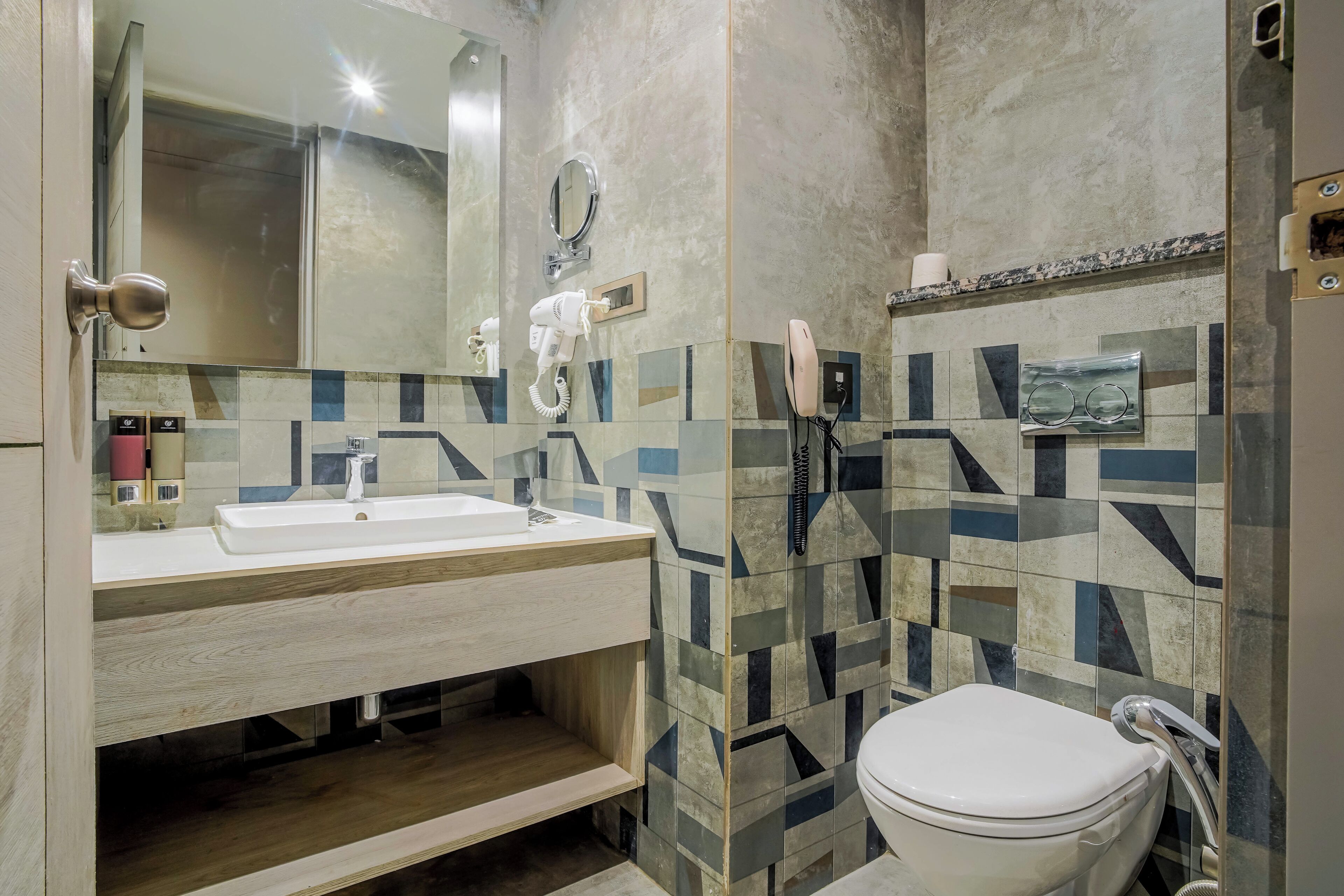 Ein modernes Badezimmer mit Waschbecken, Spiegel und Toilette.
