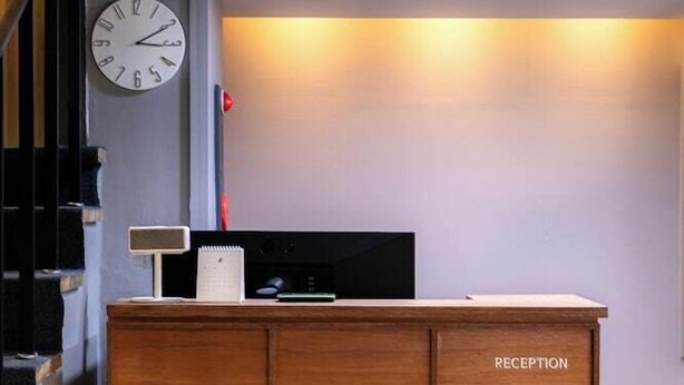 A reception desk with a clock, a flat-screen TV, and a sign labeled "RECEPTION". - Hotel Stay Inn Seoul Station (Seoul)