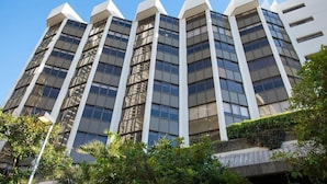 Un edificio moderno de varios pisos con fachada simétrica, ventanas amplias y techo plano.