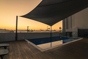A rooftop pool with a wooden deck and a large canopy. - Mainstay Suites Mackay (Mackay)