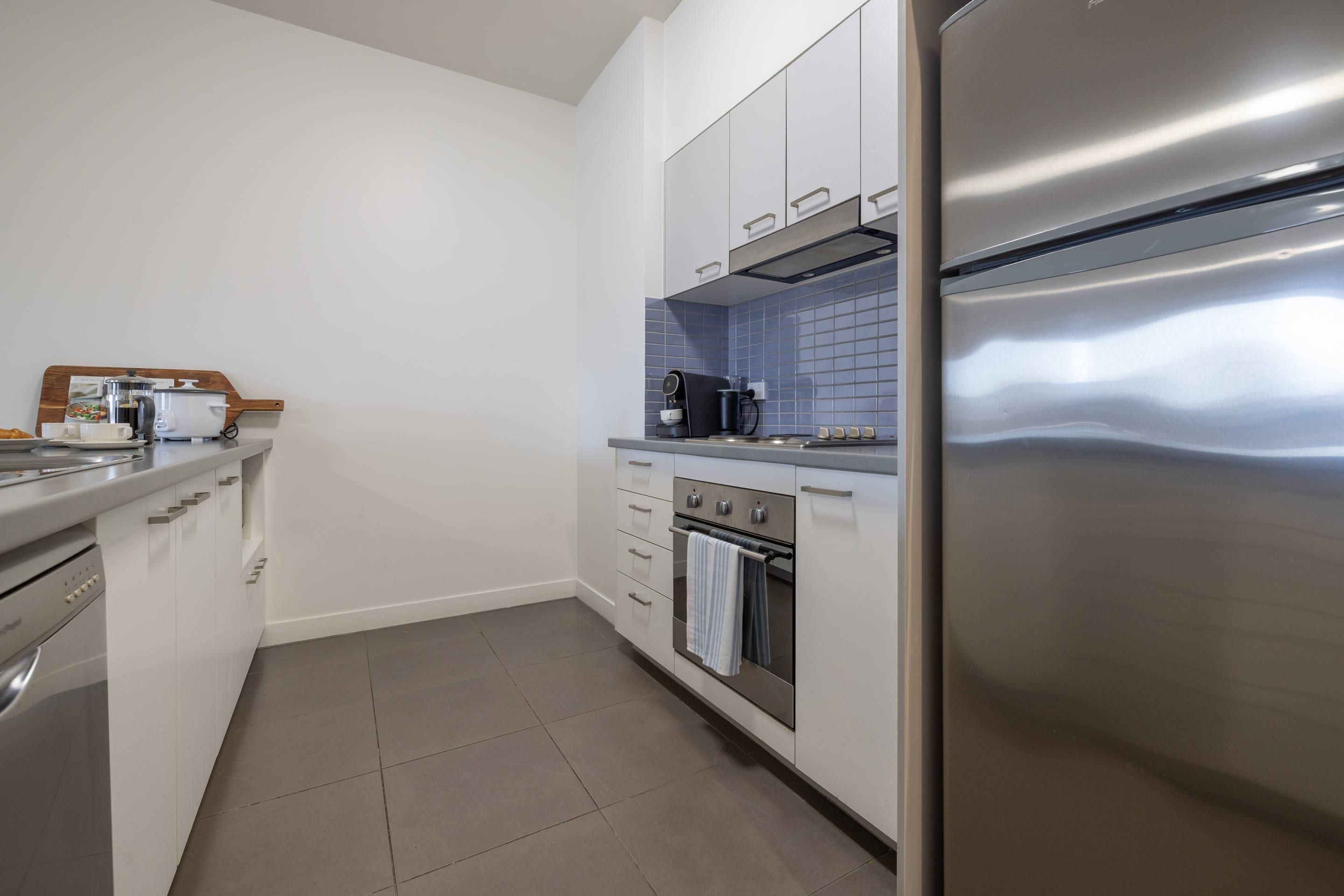 A modern kitchen with stainless steel appliances, a coffee maker, and a tray with breakfast items.