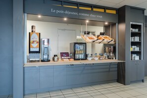 A self-service breakfast area with a coffee machine, fruit display, and a refrigerator. - B&B Hotel Rouen St Etienne Du Rouvray (Saint-Etienne-du-Rouvray)