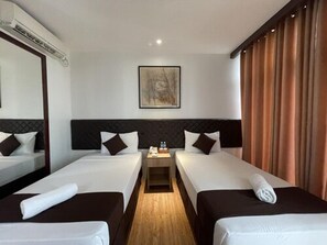 A hotel room with two beds, a nightstand, a painting on the wall, and a window with curtains. - Cebu Capitol Central Hotel and Suites Powered by Cocotel (Cebu City)