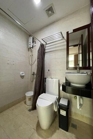 A bathroom with a toilet, bidet, sink, mirror, towel rack, and a trash bin. - Cebu Capitol Central Hotel and Suites Powered by Cocotel (Cebu City)