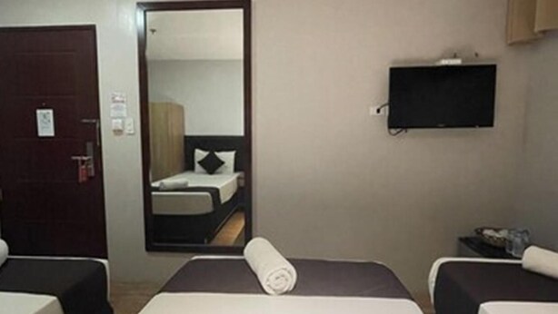 A hotel room with two beds, a TV, a mirror, and a door. - Cebu Capitol Central Hotel and Suites Powered by Cocotel (Cebu City)