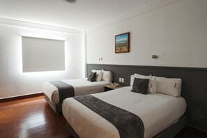 A hotel room with two beds, a window, a painting, and a wooden floor. - Eco Express Hotel Poliforum (León)