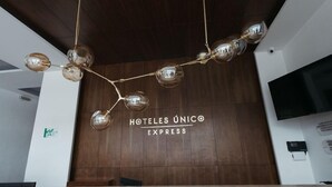 A modern hotel reception area with a wooden wall and a unique chandelier design. - Eco Express Hotel Poliforum (León)