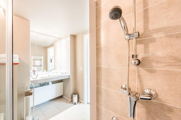 A modern bathroom with a shower, a mirror, and a sink. - Adagio Access Grenoble Université (Saint-Martin-d'Heres)