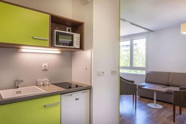 A compact kitchenette with a microwave, sink, and dishwasher. - Adagio Access Grenoble Université (Saint-Martin-d'Heres)