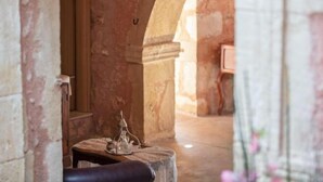 An interior corridor with a table and a chair, a decorative object on the table, and a partially visible door. - Silver Gem Villa with Private Pool (Frantzeskiana Metochia)