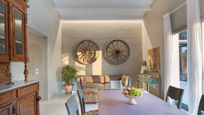 Un espace repas comprenant une table, des chaises, un buffet et deux grandes décorations murales.