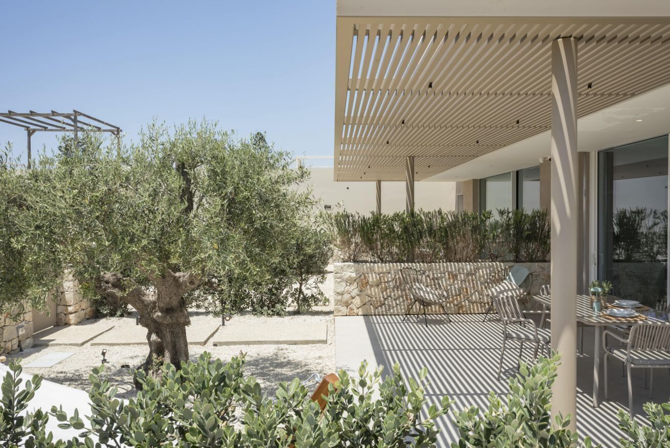 An outdoor patio with a pergola, seating area, and a view of the surrounding landscape.