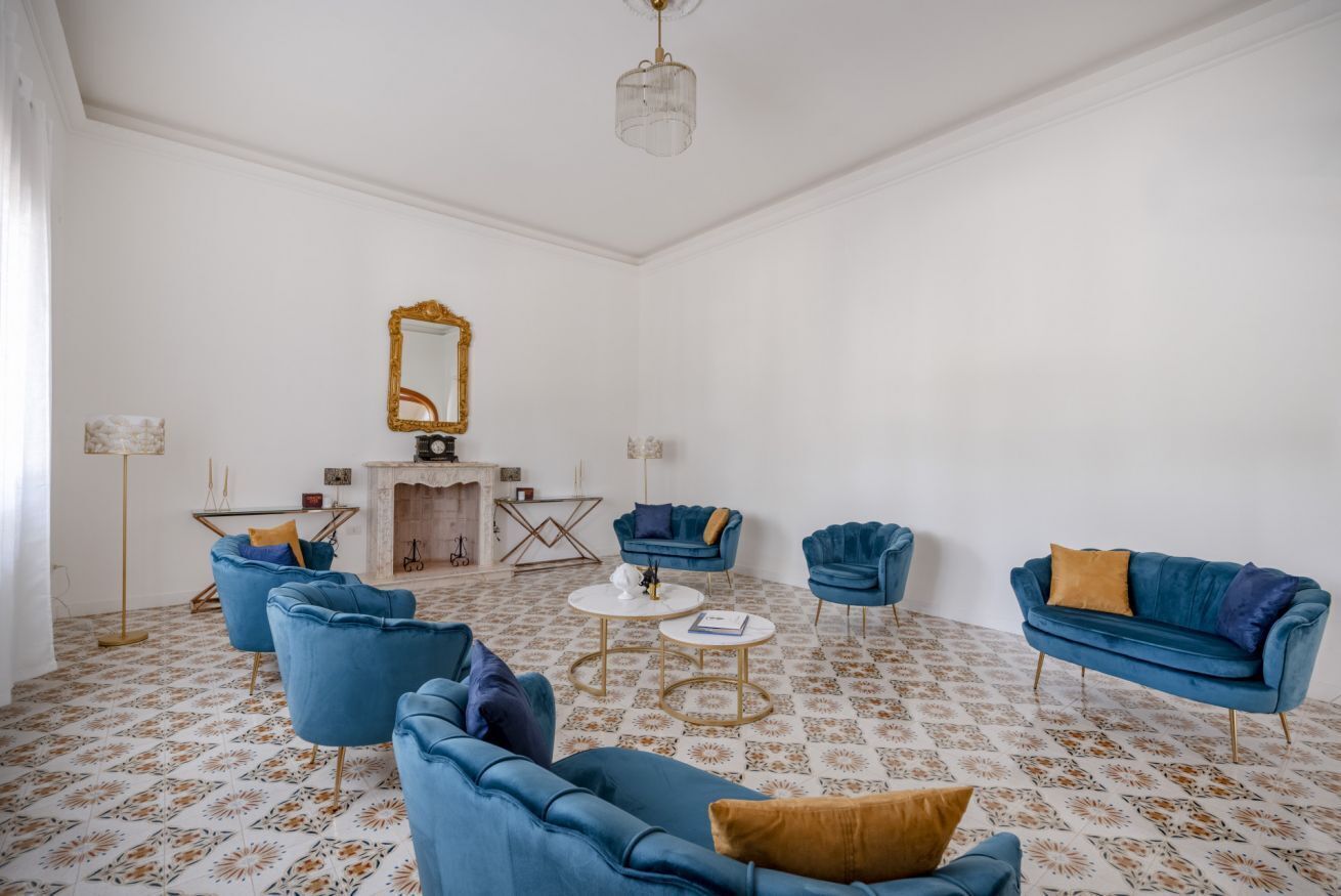 A room with a patterned floor, a large mirror, and blue furniture.
