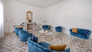 Una stanza con pavimento decorato, uno specchio grande e mobili azzurri.