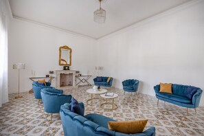 Una habitación con piso estampado, un espejo grande y muebles azules.