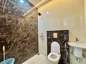 A modern bathroom with a toilet, shower, and sink.