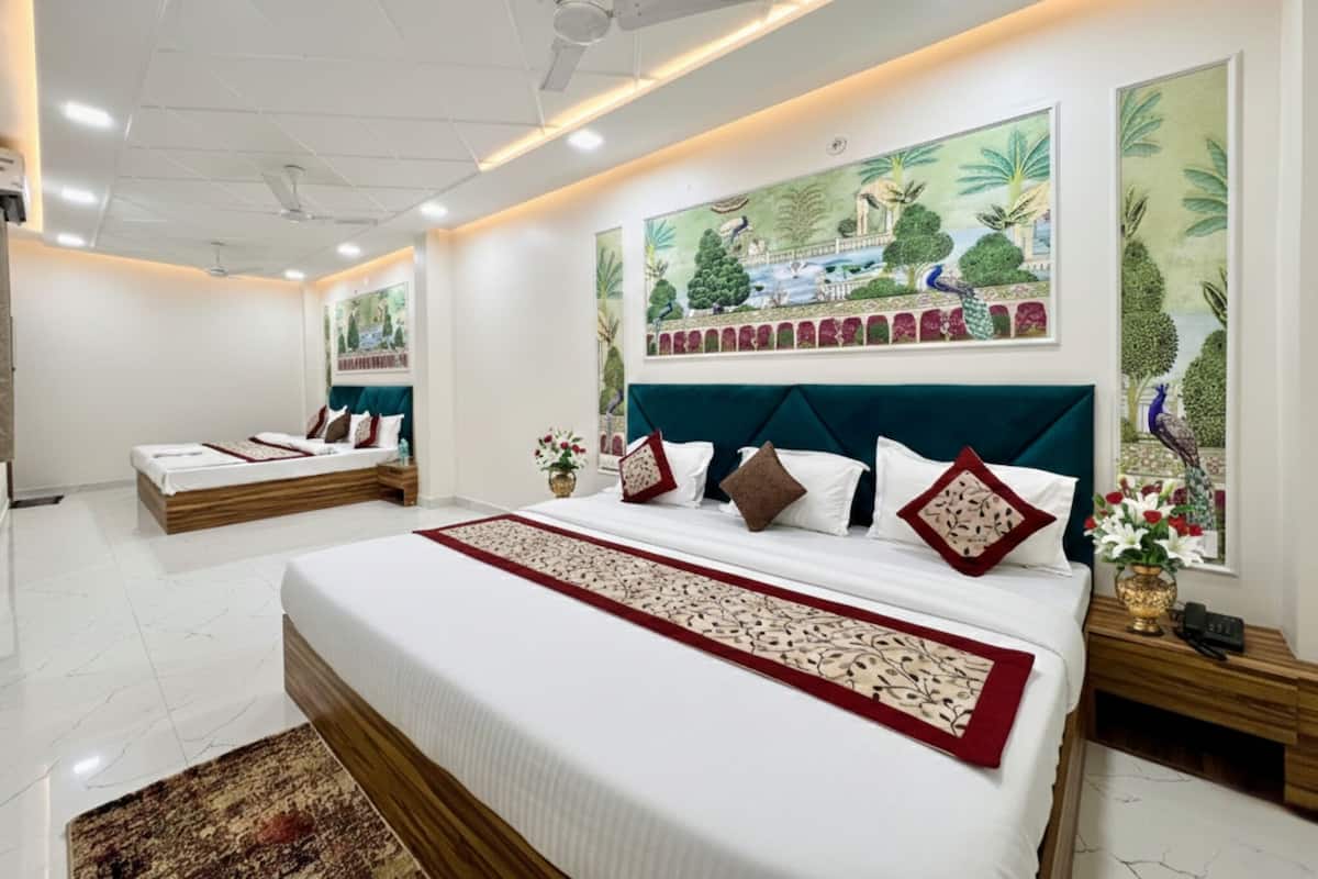A hotel room with a large bed, a smaller bed, a ceiling fan, and a mural on the wall.