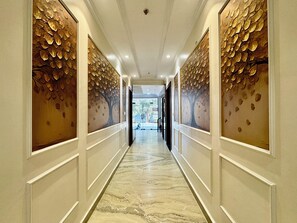 A corridor with marble flooring and decorative leaf patterns on the walls. - SR PALACE (Vrindavan)