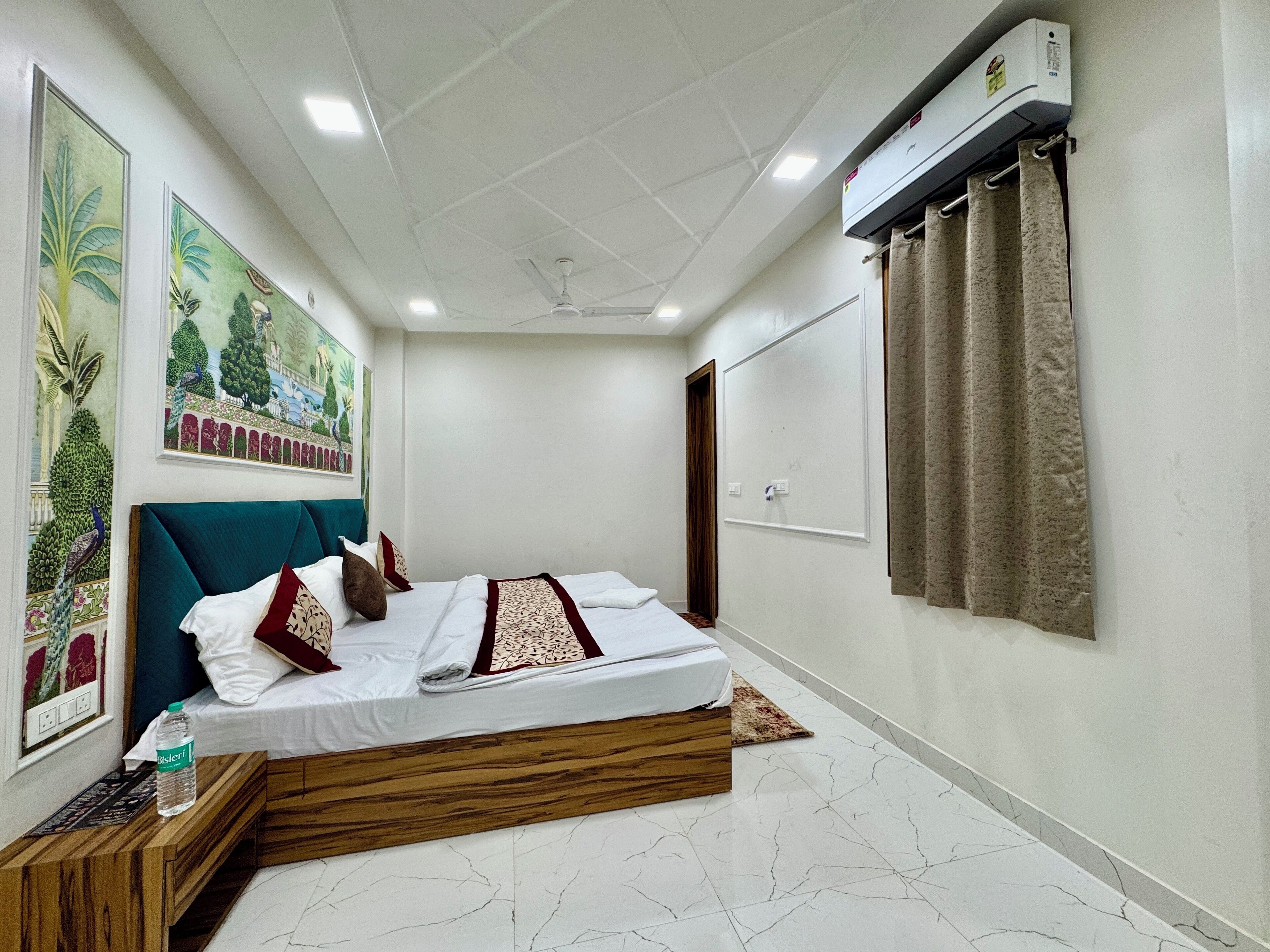 A bedroom with a bed, a wooden headboard, a ceiling fan, a wall-mounted air conditioner, and a window with curtains.