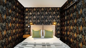 Quarto com uma cama grande, duas mesas de cabeceira e cabeceira com iluminação.